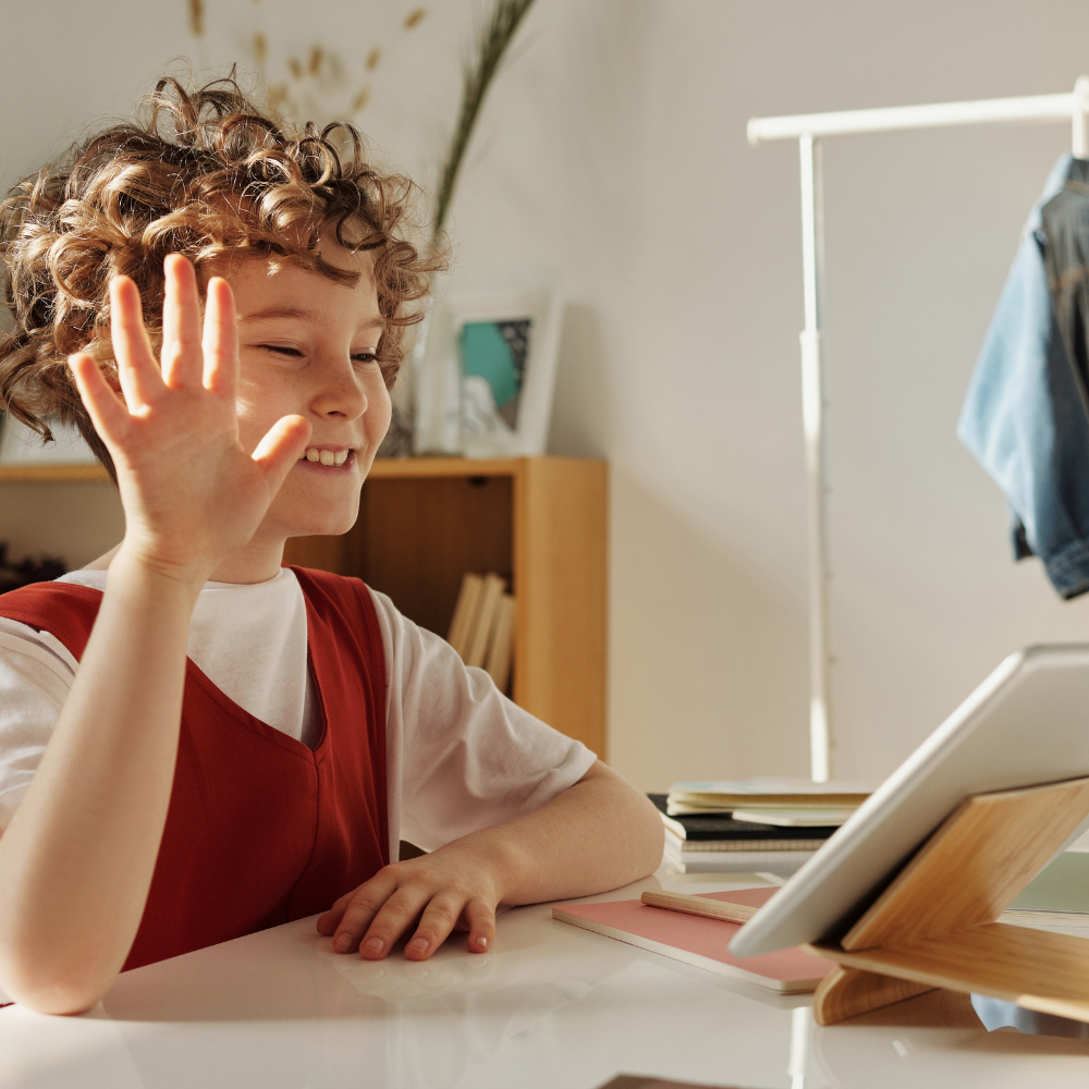 Child sitting at desk and learning using an ipad.