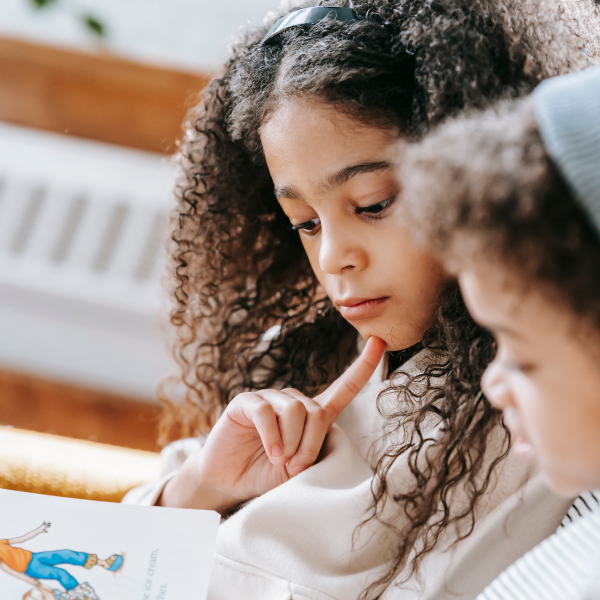 Children reading a book together.