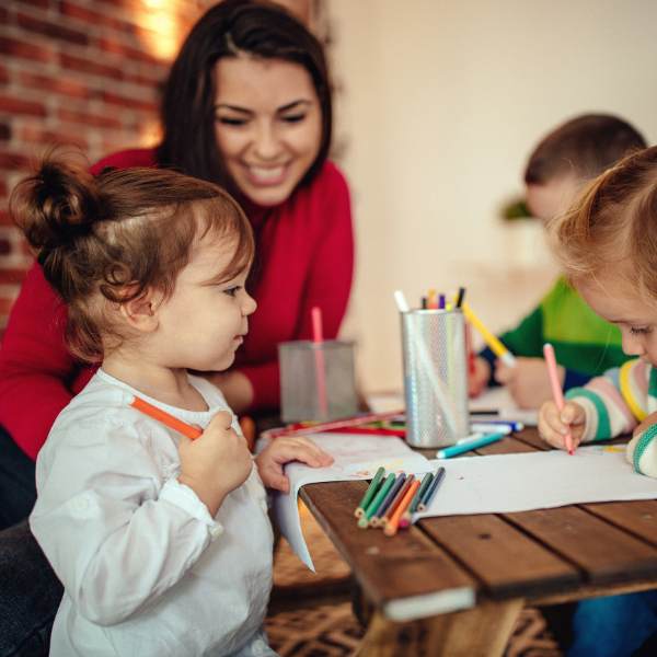 Parent and children coloring at a table.