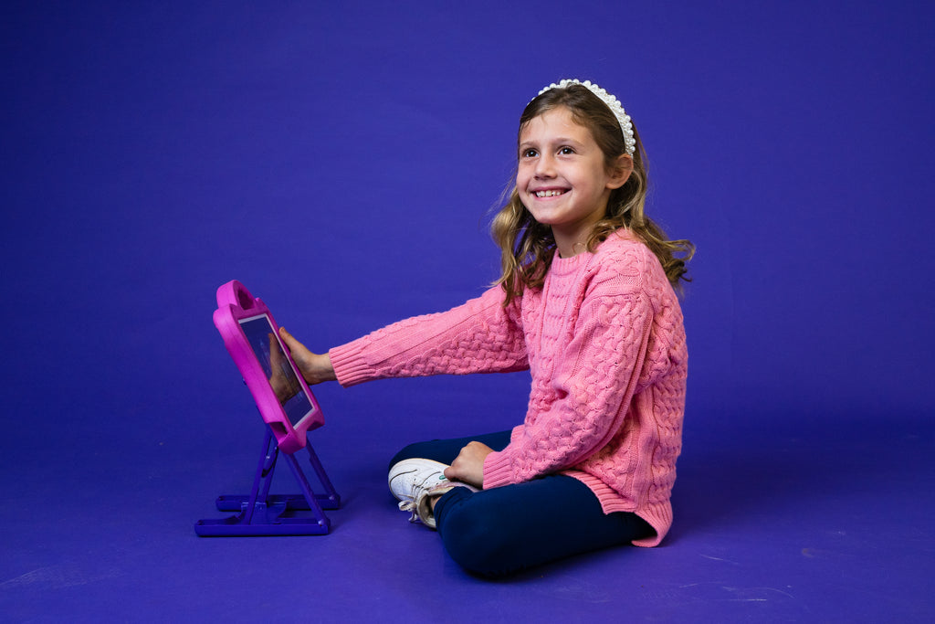 Child using pink DigiRoo ergonomic ipad case for kids.