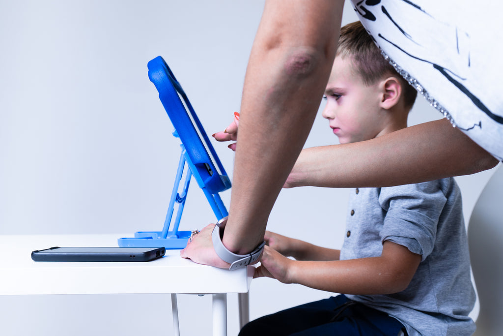 Adult helping child use ipad that is in a DigiRoo ergonomic ipad case blue.