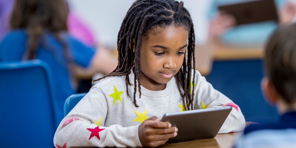 Child using ipad to learn in school.