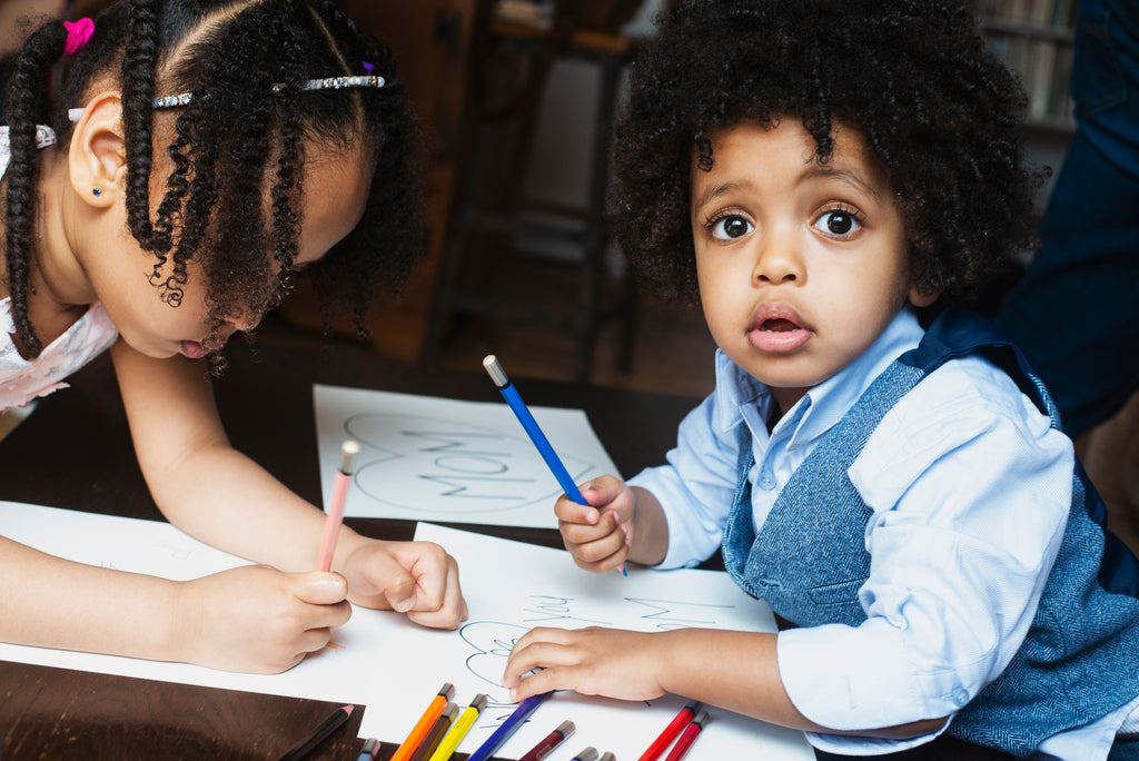 Children coloring at a table.